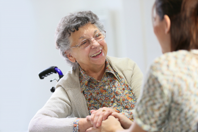 elderly woman smiling at caregiver
